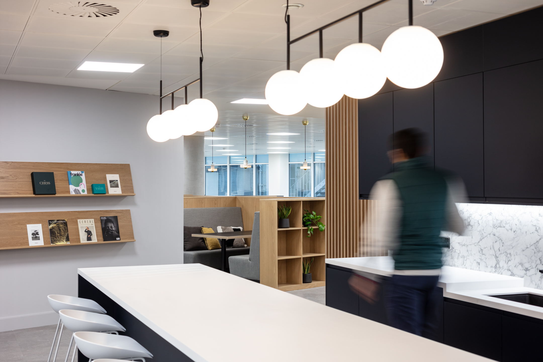 7 Bishops Gate, Level 3 05 teapoint area with hanging bespoke lighting, a bookshelf and different seating area and zones.