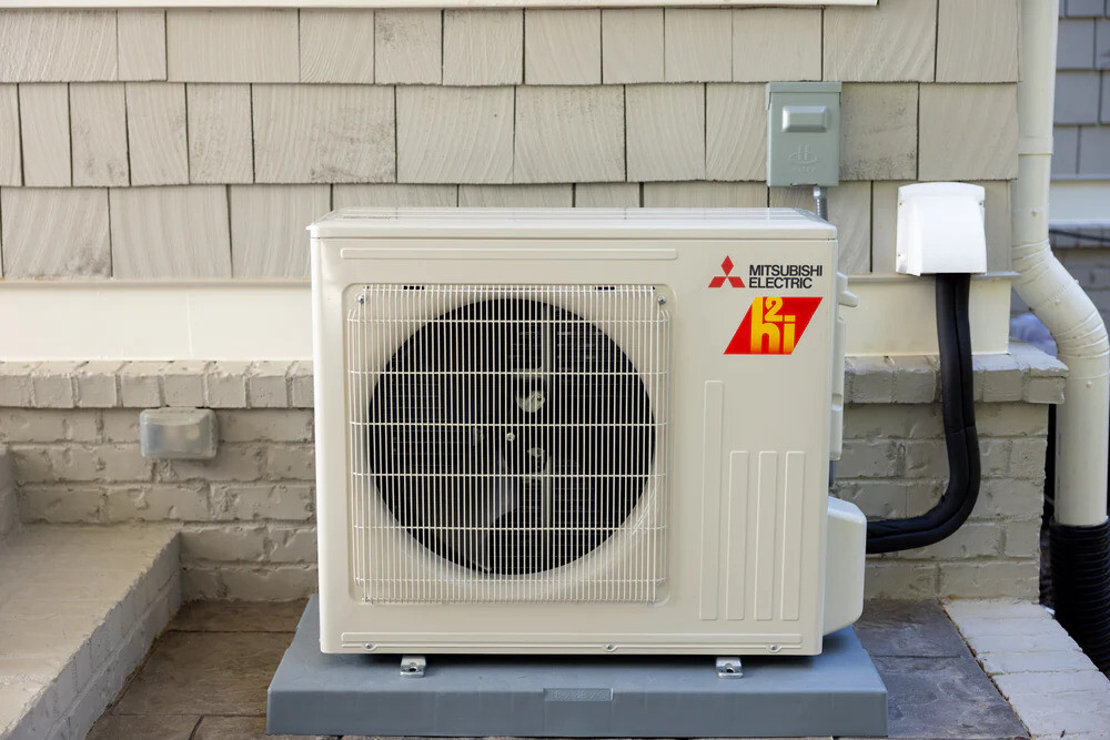 Mitsubishi Electric air source heat pump unit installed outside, representing low-carbon heating technology supported by the UK’s Boiler Upgrade Scheme.
