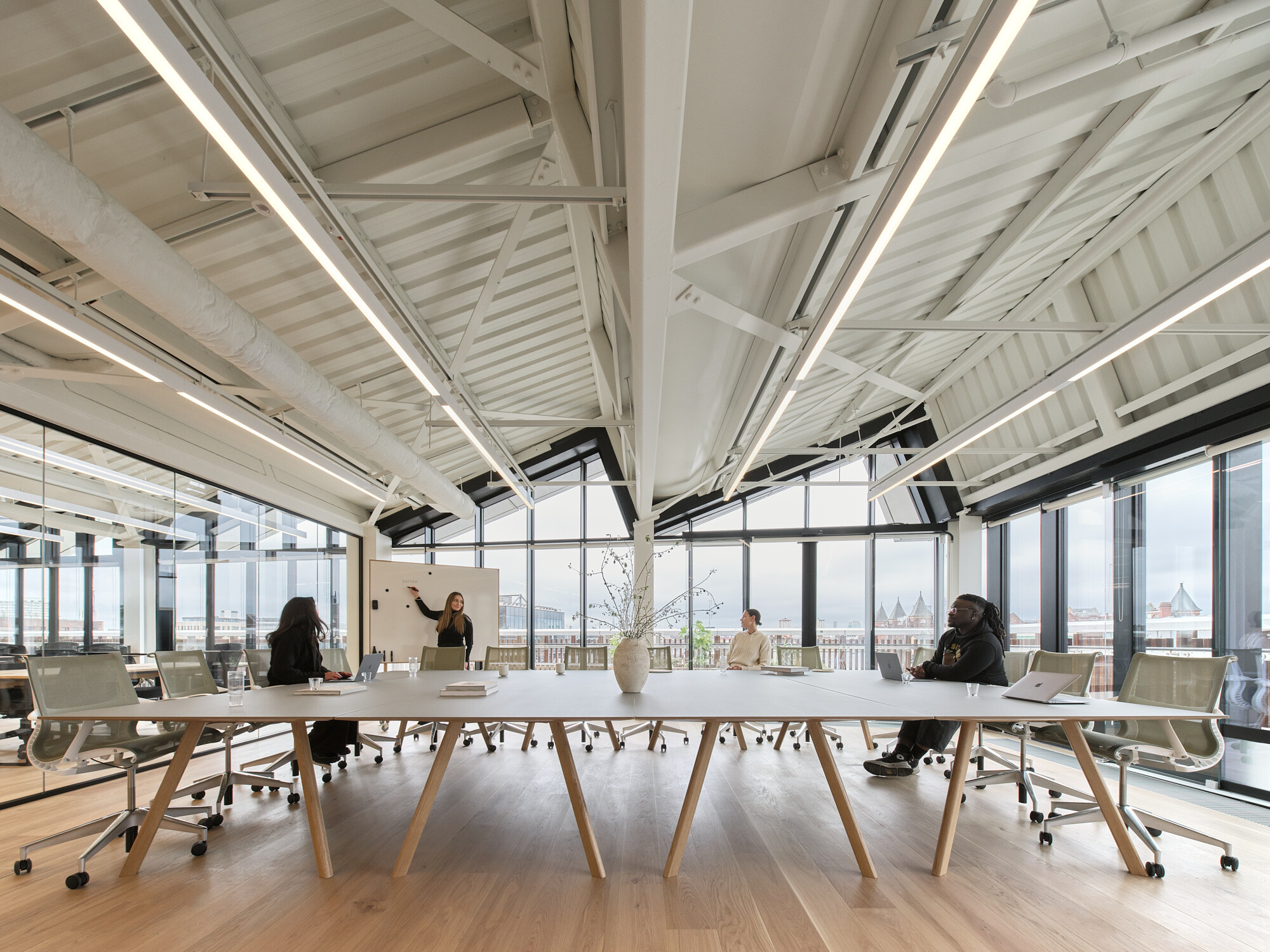 Collaborative meeting room for Labtech at Hawley Wharf with exposed roof trusses, floor-to-ceiling glazing, and views across Camden Market.