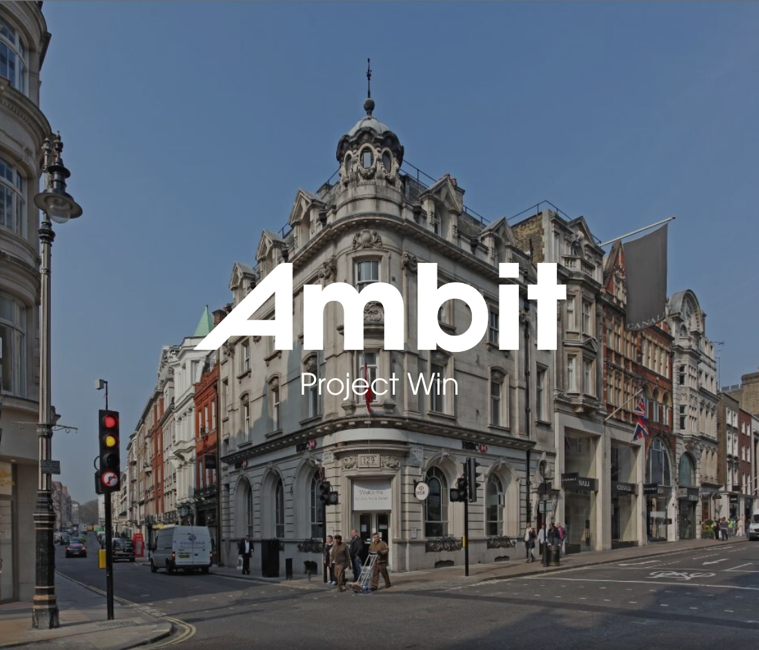 Corner view of 128–129 New Bond Street in Mayfair, featuring ornate stone architecture and retail façades, with an Ambit ‘Project Win’ graphic announcing the refurbishment.